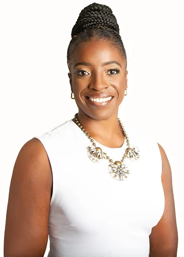 Ayanna McAlmont, smiling, in a white top and statement necklace